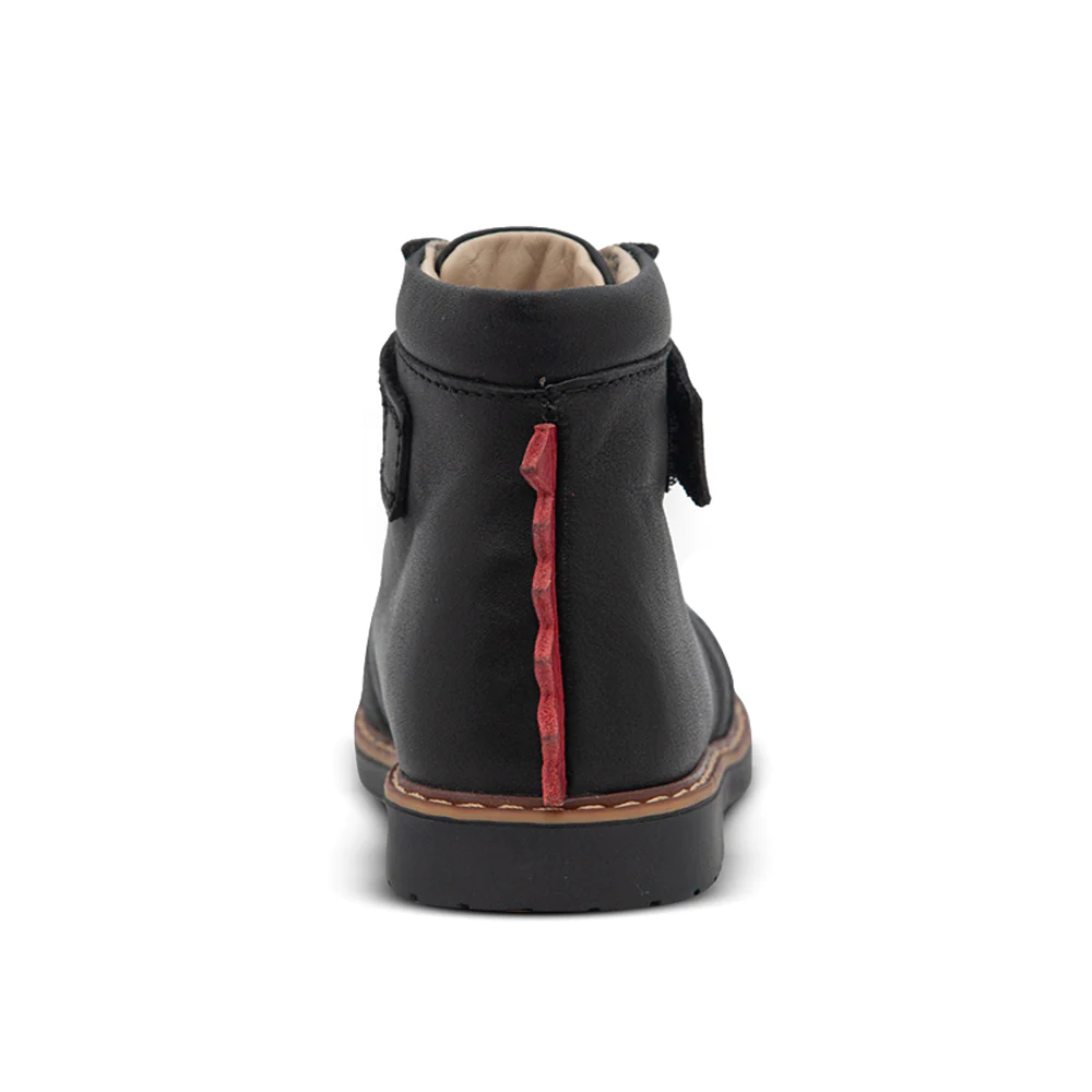 A child's boot with red spikes on the back