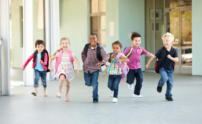 a group of children running down a hallway