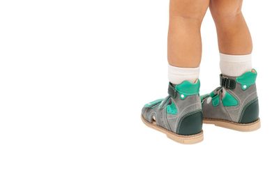 A little boy wearing a pair of high-top ankle sandals.