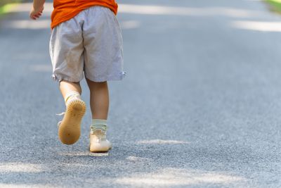 A little boy that is walking down a street.