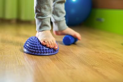 A kid doing exercises to strengthen feet and ankles.