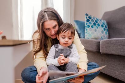 Gift ideas for kids: a mom reading a storybook to her kid.