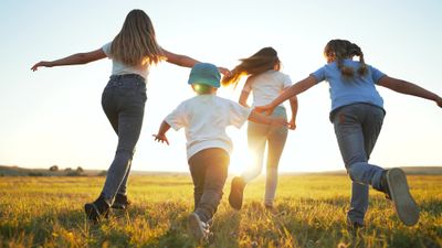 A group of children running through a field wearing shock absorbing shoes