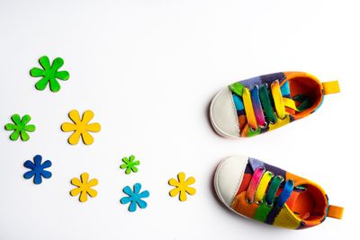 A pair of multi-colored kids' sneakers sitting on top of a white surface