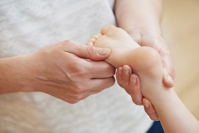 A parent massaging their child's foot to alleviate growing pains