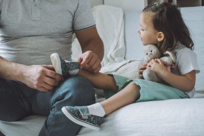 A man sitting on a couch with a little girl.