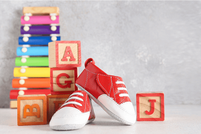 a pair of red shoes sitting next to a stack of blocks