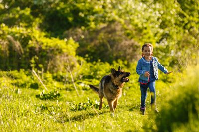 A little girl running in a field with durable shoes.