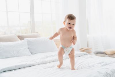 Baby's sweaty feet: a toddler walking barefoot across a bed.