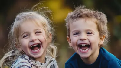 two young children are laughing and posing for a picture