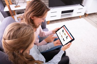 A parent and child browsing shoes to buy online