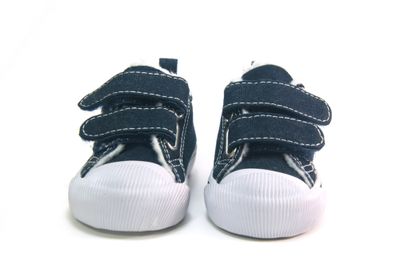 a close up of a pair of navy children's shoes on a white surface
