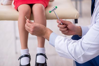 Knock knees: a doctor checking a girl's knees.