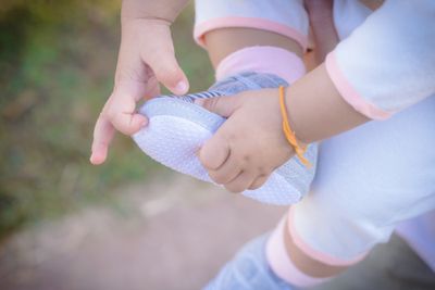 A baby holding on to her pre walker shoes.