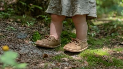 A little girl standing on top of a lush green forest.