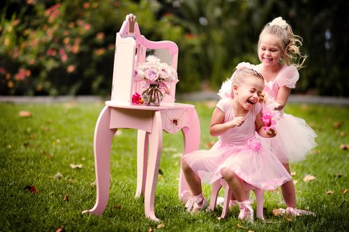 Two little girls in pink dresses wearing play shoes for girls.