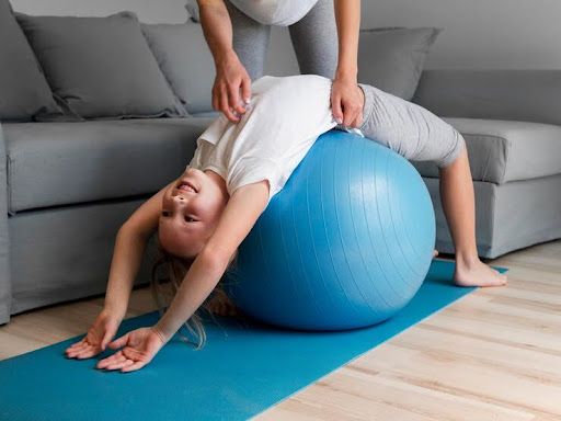 a woman doing a back stretch on a blue exercise ball