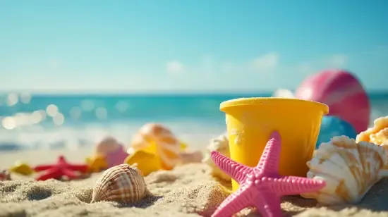 a beach scene with a starfish, shells, and a bucket