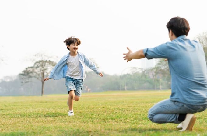 a man and a young boy playing a game of frisbee