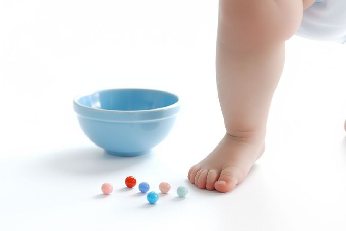 A baby doing a marble pickup exercise.