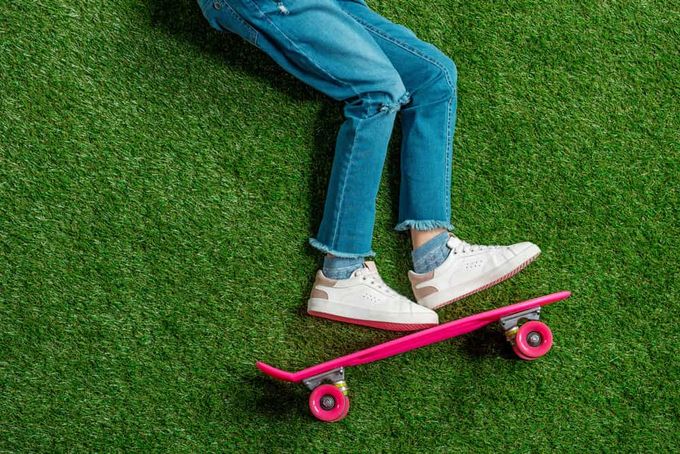 High-tops vs. low-tops: a kid wearing low tops standing on a skateboard.