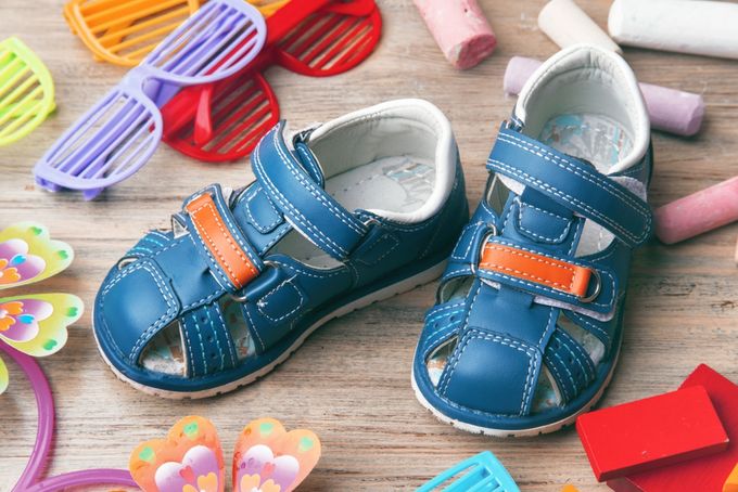 A pair of blue boys sandals among other summer paraphernalia