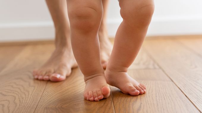a close up of a child's bare feet on a wooden floor