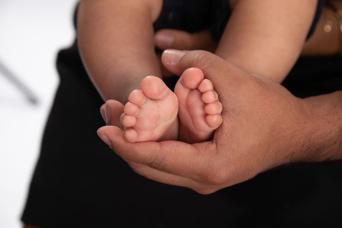 A close up of a mother holding her baby's feet.