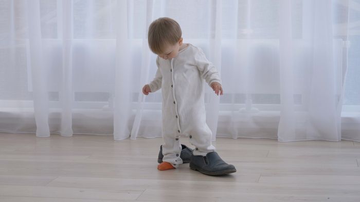 A child looking at the difference between kids and adult shoes.