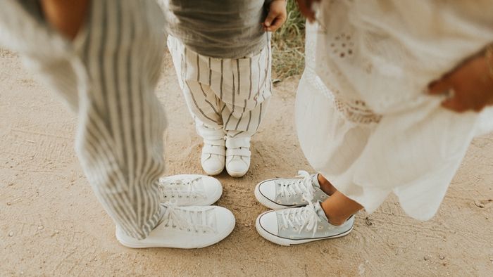 Family photo showing mother and kids standing next to each other and wearing white high-top sneakers