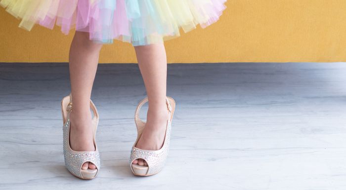 A toddler in a colorful dress and high heels - Is it Bad for Toddlers to Wear Shoes That Are Too Big