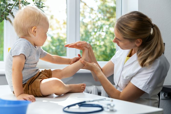 A podiatrist checking a toddler's foot.