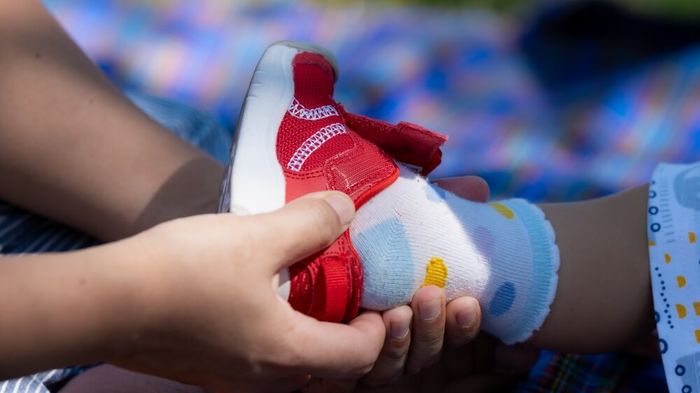 A close up of a shoe being fitted on a child's foot.