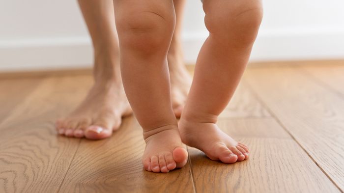 a close up of a child's bare feet on a wooden floor