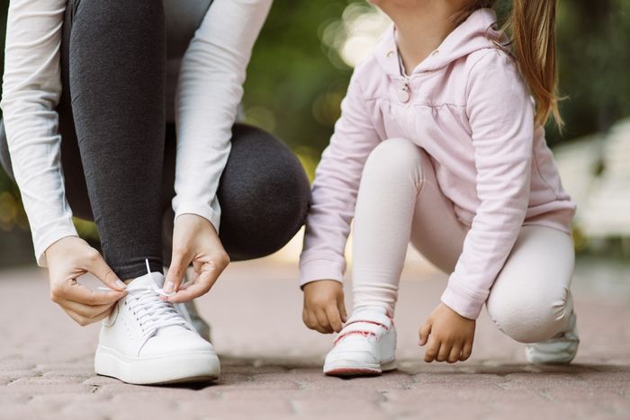 How to stretch out shoes: A mother and a daughter tying their shoes.