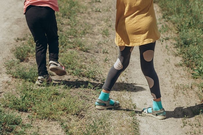 Two girls in a field, one with straight legs and the other one with knock knees