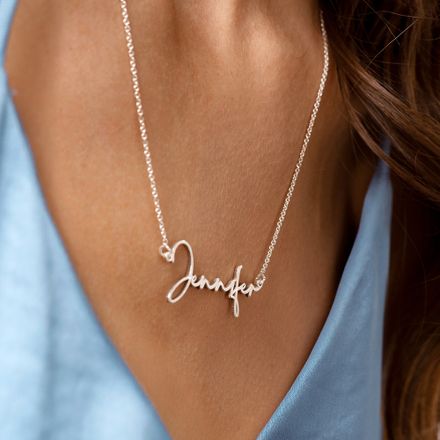 a woman wearing a name necklace with a heart