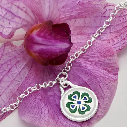 a close up of a clover on a necklace