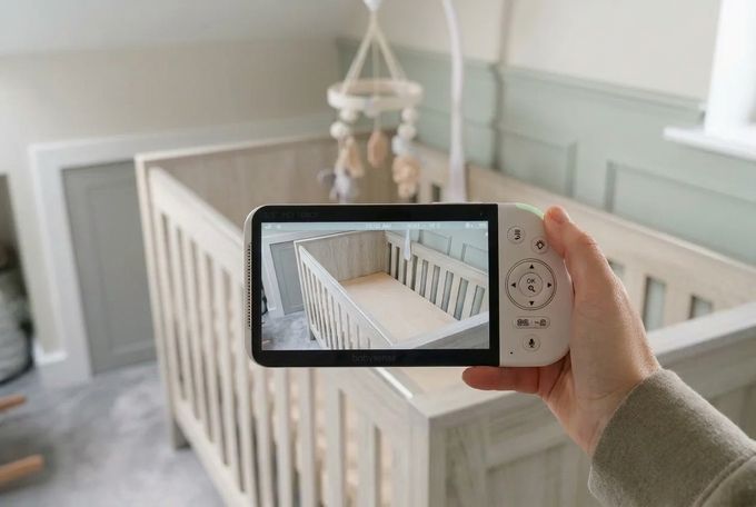a person taking a picture of a baby crib