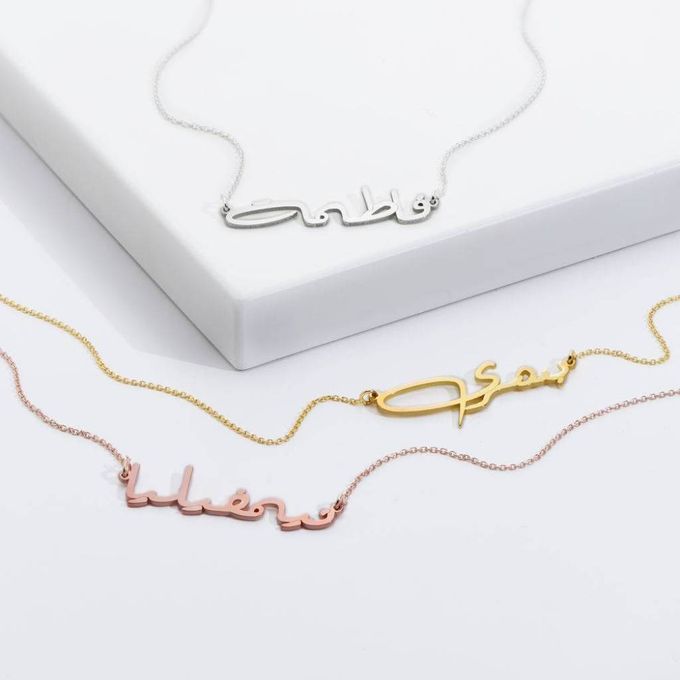 three arabic name necklaces on a white background