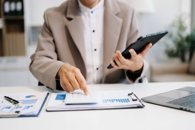 a man sitting at a desk with a tablet and looking at financial stocks