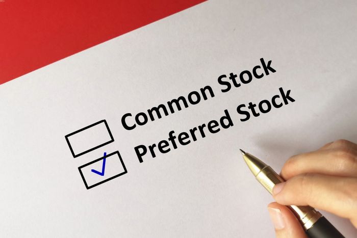 A person holding a pen after checking preferred stock option