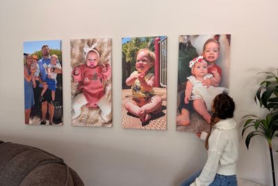 A woman looking at canvas frames.