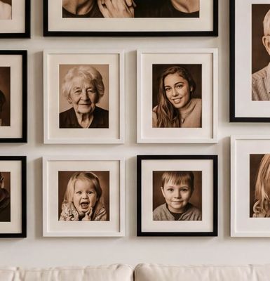 a white couch sitting next to a wall covered in pictures