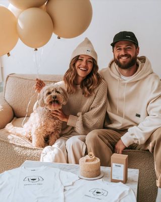a man and woman sitting on a couch with a dog