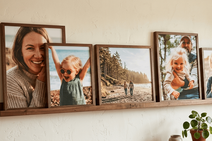 11 Gallery Wall Layout Ideas for a Flawless Display A wall gallery layout using different sized wooden framed portraits.