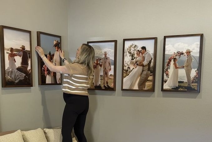 11 Gallery Wall Layout Ideas for a Flawless Display A woman setting up a corner wall gallery layout design.