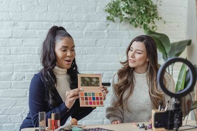 Two women creating an engaging product video showing a makeup palette