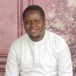 a man in a white shirt sitting in front of a painting