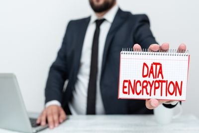 a man in a suit holding a note that says data encryption